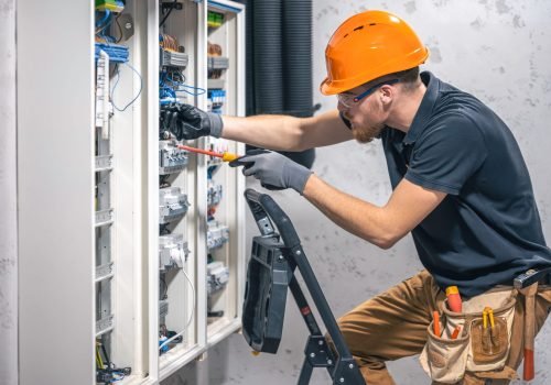 young-adult-electrician-civil-engineer-screwing-equipment-into-fuse-box (1)